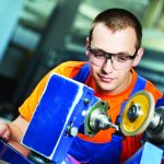 industrial worker at sharpening machine tool