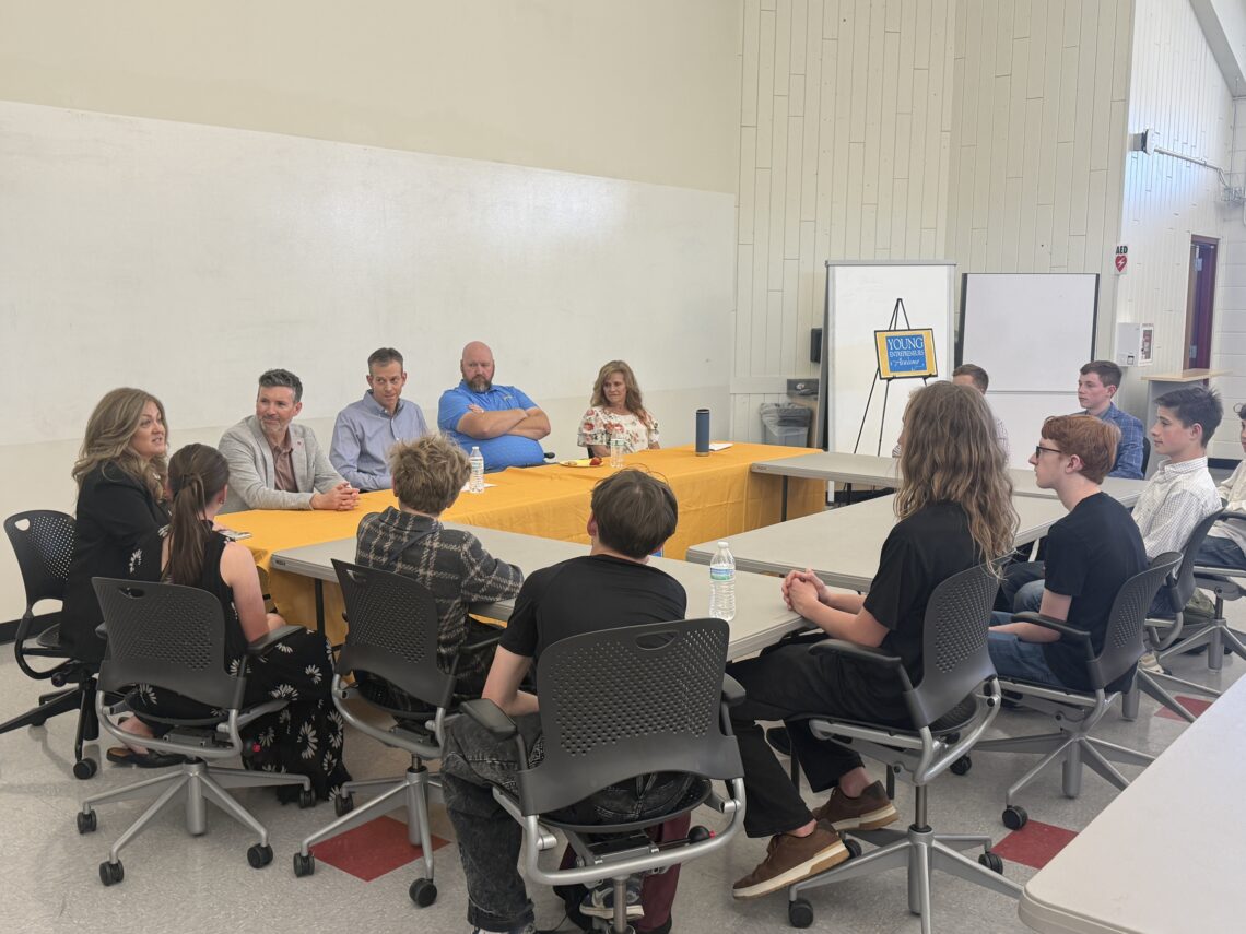 YEA students and local CEOs sitting around a round table.