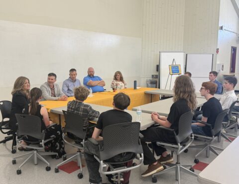 YEA students and local CEOs sitting around a round table.