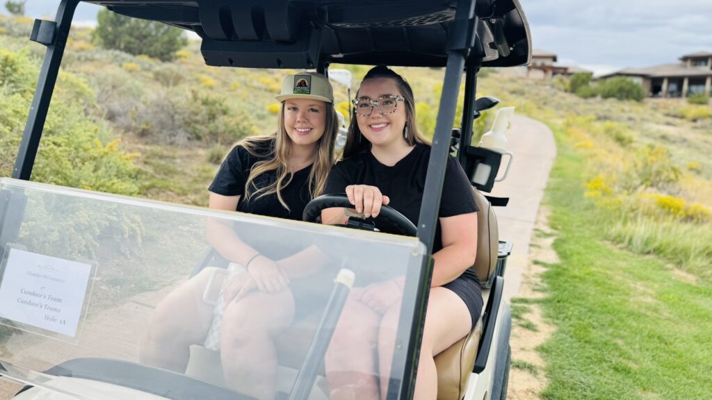 Participants of the Grand Junction Chamber Golf Tournament on a golf cart